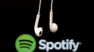 FILE PHOTO: Headphones are seen in front of a logo of online music streaming service Spotify